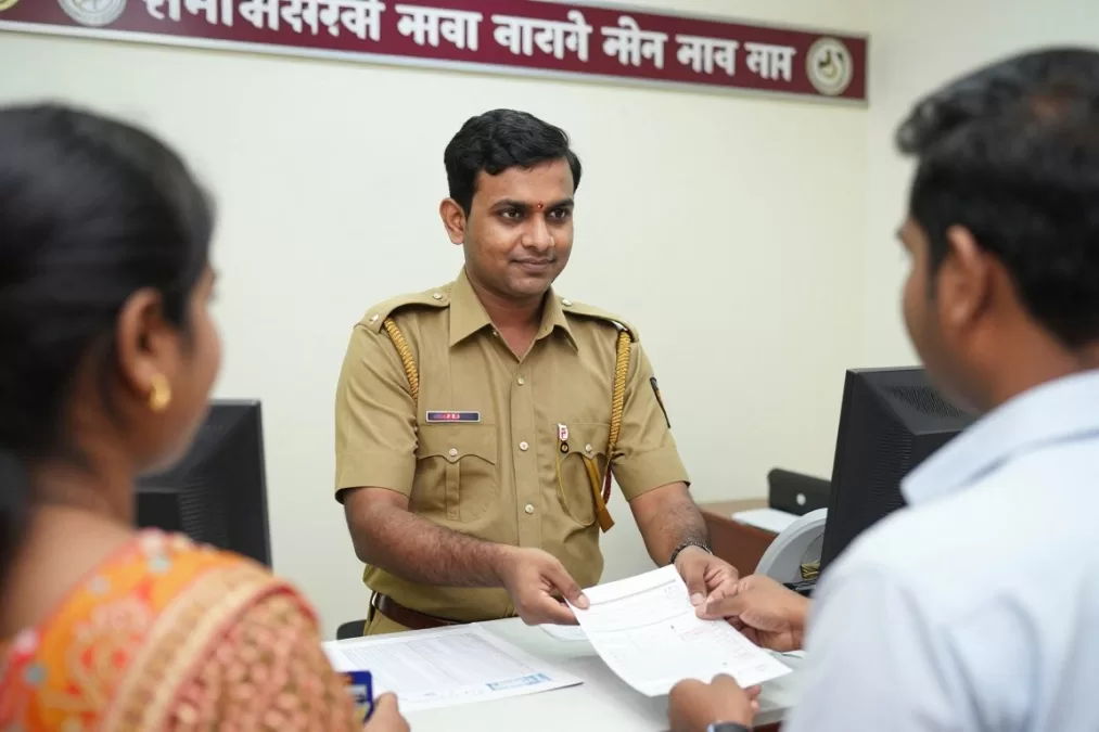 Indian postal worker at post office counter serving customers